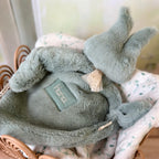 Quoi de mieux que de créer un doudou pensé par un enfant ? Alors c'est chose faite ! Nous avons demandé à notre petite mascotte, d'imaginer son doudou parfait : il serait en forme de lapin, extrêmement doux, avec une partie à cajoler. Le doudou lapin se compose d'une fourrure extra douce sur l'intégralité de son corps.  Une association idéale pour un doudou ultra-câlin.  Son petit plus : deux petits liens en dentelle vous permettront d’attacher une tétine si besoin. La dentelle peut légèrement varier d’un d