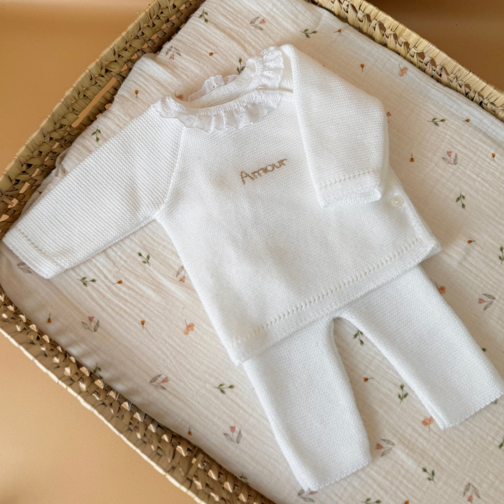 Offrez à votre nouveau-né douceur et confort avec notre petit pantalon de naissance en maille, couleur blanc. Conçu spécialement pour les tout-petits, ce pantalon est tricoté avec soin en France, dans une maille souple et agréable, parfaite pour la peau délicate des bébés. Sa taille élastiquée assure un ajustement confortable sans comprimer le ventre de bébé, tout en facilitant l’habillage au quotidien. Minimaliste et élégant, il est idéal dès les premiers jours de vie, que ce soit pour rester bien au chaud