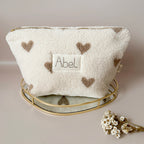 La trousse de toilette pour bébé est une pièce personnalisée et pratique, conçue avec soin pour répondre aux besoins des parents et de leur nouveau-né. Son grand format est très pratique.  La conception de la trousse permet aux produits de bébé de tenir debout à l'intérieur, ce qui facilite l'organisation et l'accès aux produits essentiels. Liniment, couches, lait de toilette, cotons, autant de produits pour un si petit bout de chou, que vous aurez besoin d'une grande trousse de toilette spacieuse. Fabriqué