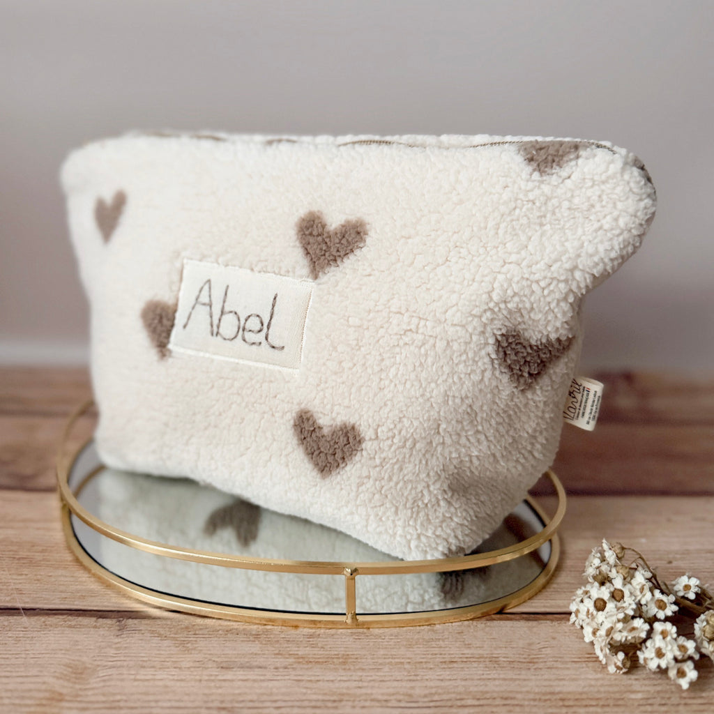 La trousse de toilette pour bébé est une pièce personnalisée et pratique, conçue avec soin pour répondre aux besoins des parents et de leur nouveau-né. Son grand format est très pratique.  La conception de la trousse permet aux produits de bébé de tenir debout à l'intérieur, ce qui facilite l'organisation et l'accès aux produits essentiels. Liniment, couches, lait de toilette, cotons, autant de produits pour un si petit bout de chou, que vous aurez besoin d'une grande trousse de toilette spacieuse. Fabriqué