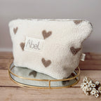 La trousse de toilette pour bébé est une pièce personnalisée et pratique, conçue avec soin pour répondre aux besoins des parents et de leur nouveau-né. Son grand format est très pratique.  La conception de la trousse permet aux produits de bébé de tenir debout à l'intérieur, ce qui facilite l'organisation et l'accès aux produits essentiels. Liniment, couches, lait de toilette, cotons, autant de produits pour un si petit bout de chou, que vous aurez besoin d'une grande trousse de toilette spacieuse. Fabriqué