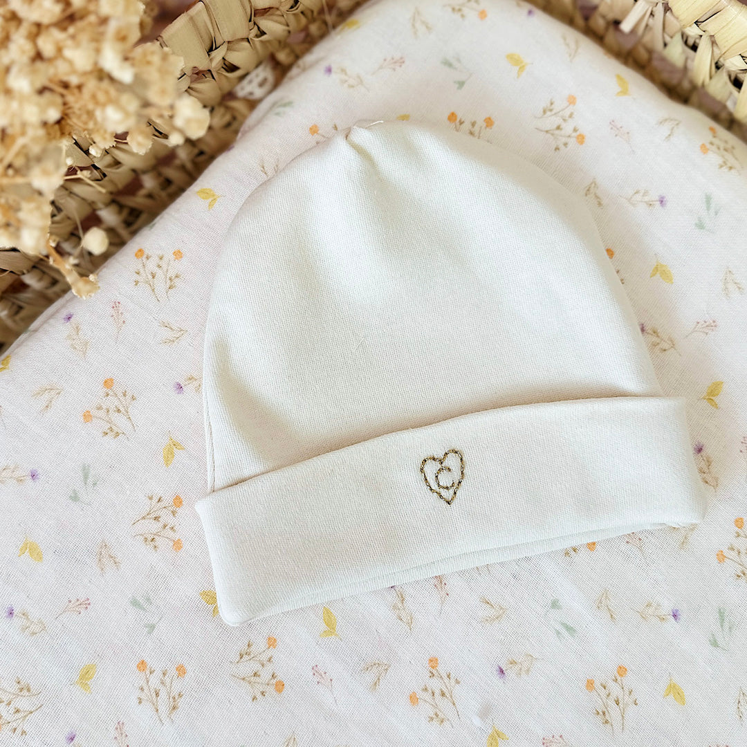 Immortaliser les premiers jours de vie de bébé avec ce joli petit bonnet personnalisé. Il est en 100% jersey de coton biologique écru. Il sera réchauffer bébé. Idéale pour annoncer le prénom de bébé à la naissance ! Le saviez-vous? Toutes les extrémités du corps de bébé sont les plus vulnérables au froid , pieds, mains, oreilles ... Même en plein été il est important de bien couvrir bébé dès la naissance, n'oublions pas qu'il sort d'un bain de 37° C depuis 9 mois !