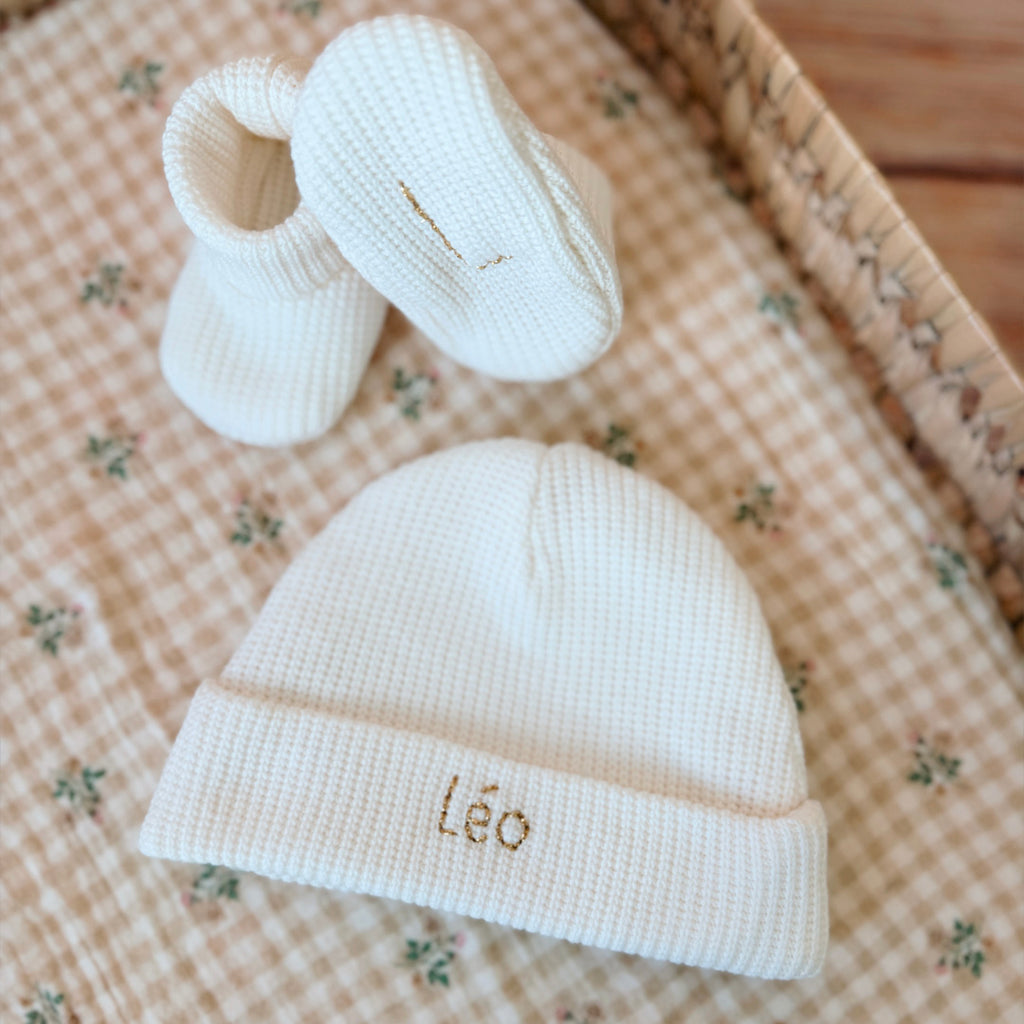 Le bonnet de naissance, un incontournable dans la valise maternité Le bonnet de naissance personnalisé pour bébé en maille tricotée de coton est l'accessoire idéal pour les premiers jours de votre nouveau-né. Confectionné avec soin, ce bonnet offre à votre bébé douceur et confort incomparables. Il est fabriqué dans l’un de nos ateliers partenaires français. Un cadeau parfaitement adapté pour accueillir votre petit trésor dans le monde avec tendresse et douceur. Retrouvez dans la même gamme, nos petits chaus