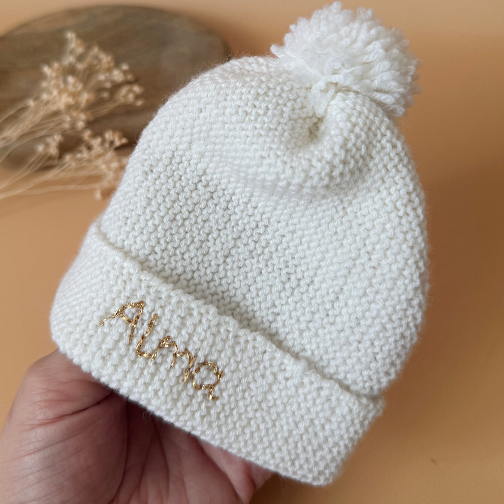Le bonnet de naissance personnalisé pour bébé en maille tricotée de coton est l'accessoire idéal pour les premiers jours de votre nouveau-né. Confectionné avec soin, ce bonnet offre à votre bébé douceur et confort incomparables. Il est fabriqué dans l’un de nos ateliers partenaires français. Un cadeau parfaitement adapté pour accueillir votre petit trésor dans le monde avec tendresse et douceur. Retrouvez dans la même gamme, nos petits chaussons de naissance. Grâce à sa texture et à sa conception, ce bonnet