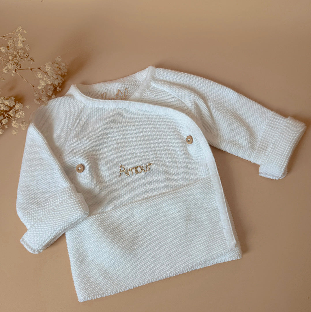Pour un nourrisson, de la naissance à un mois environ, il est recommandé de rajouter une brassière de naissance en coton  et un bonnet.  À cet âge bébé est encore trop petit pour réguler lui-même sa température. Bébé a besoin de chaleur et de matières douces et rassurantes, c'est pourquoi ce cardigan croisé est un parfait cocon pour accueillir bébé ! Elle a une place indispensable dans le trousseau de maternité. Complétez votre tenue avec un de nos petits bonnets personnalisés et nos petits chaussons de nai