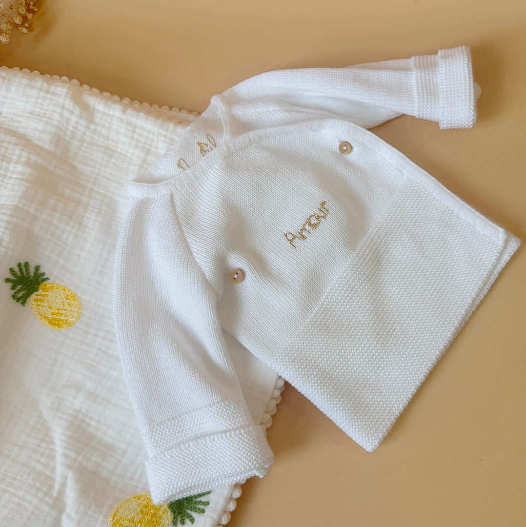 Pour un nourrisson, de la naissance à un mois environ, il est recommandé de rajouter une brassière de naissance en coton  et un bonnet.  À cet âge bébé est encore trop petit pour réguler lui-même sa température. Bébé a besoin de chaleur et de matières douces et rassurantes, c'est pourquoi ce cardigan croisé est un parfait cocon pour accueillir bébé ! Elle a une place indispensable dans le trousseau de maternité. Complétez votre tenue avec un de nos petits bonnets personnalisés et nos petits chaussons de nai
