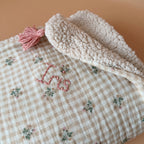 La couverture est une des pièces indispensable du trousseau de bébé. Parfaite en cadeau de naissance ou à s’offrir soit même, cette couverture demie saison est parfaite pour accompagner bébé tout au long de l'année, Cette grande couverture pourra également être utilisée en descente de lit quand bébé sera plus grand. Cette couverture est idéale pour bien réchauffer les bébés en demie saison grâce à sa fausse fourrure type sherpa mouton beige , et sa doublure en gaze de coton hypoallergénique au magnifique mo