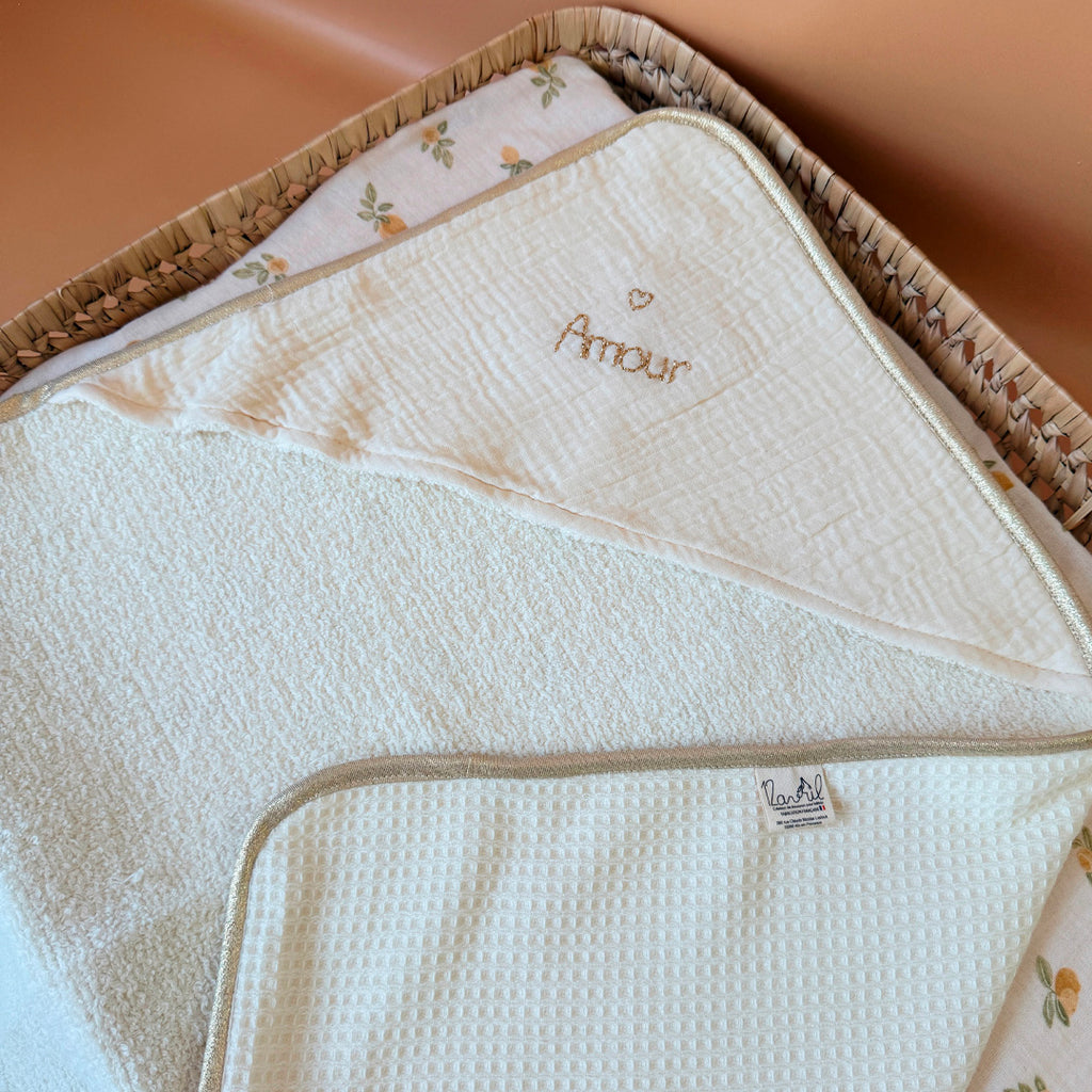 Offrez à votre nouveau-né une sortie de bain tout en douceur avec notre cape de bain de naissance en nid d’éponge, confectionnée en coton 100% naturel. Cette cape innovante associe deux textures complémentaires : L’éponge ultra absorbante, idéale pour sécher bébé rapidement, Et le nid d’abeille moelleux, parfait pour envelopper délicatement sa peau fragile. Sa forme carrée de 70 x 70 cm est spécialement pensée pour les tout-petits. Elle épouse parfaitement la taille de bébé pendant ses premiers mois, sans e