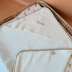 Offrez à votre nouveau-né une sortie de bain tout en douceur avec notre cape de bain de naissance en nid d’éponge, confectionnée en coton 100% naturel. Cette cape innovante associe deux textures complémentaires : L’éponge ultra absorbante, idéale pour sécher bébé rapidement, Et le nid d’abeille moelleux, parfait pour envelopper délicatement sa peau fragile. Sa forme carrée de 70 x 70 cm est spécialement pensée pour les tout-petits. Elle épouse parfaitement la taille de bébé pendant ses premiers mois, sans e
