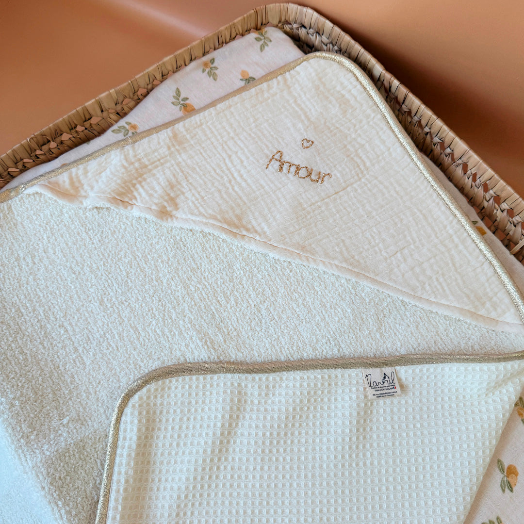 Offrez à votre nouveau-né une sortie de bain tout en douceur avec notre cape de bain de naissance en nid d’éponge, confectionnée en coton 100% naturel. Cette cape innovante associe deux textures complémentaires : L’éponge ultra absorbante, idéale pour sécher bébé rapidement, Et le nid d’abeille moelleux, parfait pour envelopper délicatement sa peau fragile. Sa forme carrée de 70 x 70 cm est spécialement pensée pour les tout-petits. Elle épouse parfaitement la taille de bébé pendant ses premiers mois, sans e