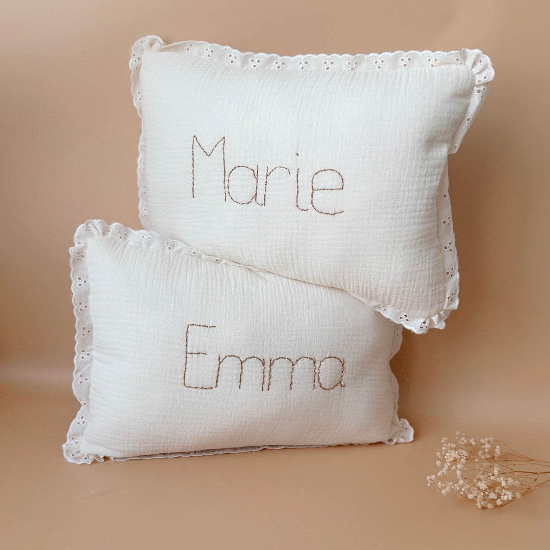 Offrez à la chambre de votre enfant une touche d'élégance et de douceur avec ce coussin rectangulaire très raffiné. Confectionné avec soin, il allie la gaze de coton et la maille de nid d'abeille grattée, des matériaux à la fois légers, aérés et agréables au toucher. Son coloris écru intemporel s'intégrera parfaitement dans tout type de décoration, apportant à la pièce une ambiance chaleureuse et apaisante. Ce coussin n'est pas seulement un accessoire de décoration, il devient aussi un objet personnalisé et