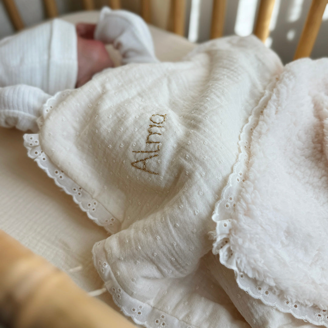 La couverture est une des pièces indispensable du trousseau de bébé. Parfaite en cadeau de naissance ou à s’offrir soit même, cette couverture demie saison est aprfaite pour accompagner bébé tout au long de l'année, Cette grande couverture pourra également être utilisée en descente de lit quand bébé sera plus grand. Cette couverture est idéale pour bien réchauffer les bébés en demie saison grâce à sa fausse fourrure type sherpa mouton beige , et sa doublure en gaze de coton hypoallergénique au magnifique mo