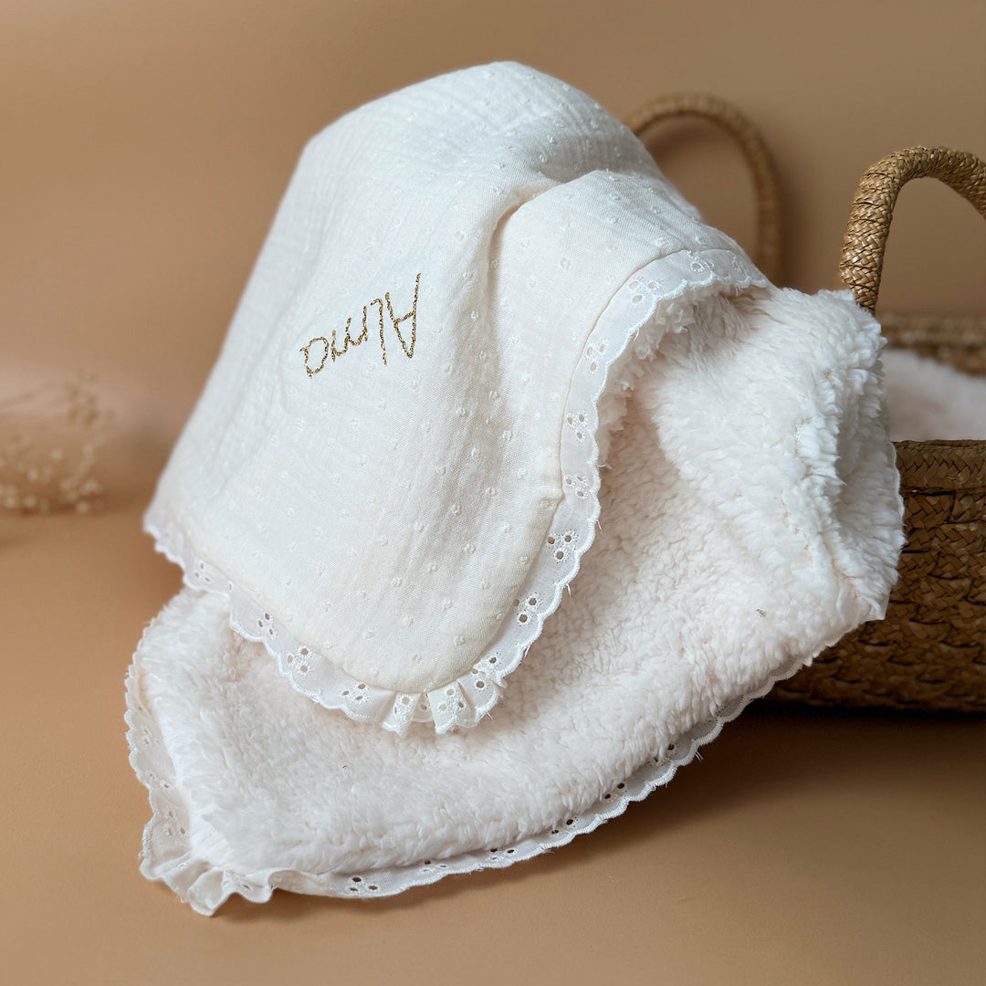 La couverture est une des pièces indispensable du trousseau de bébé. Parfaite en cadeau de naissance ou à s’offrir soit même, cette couverture demie saison est aprfaite pour accompagner bébé tout au long de l'année, Cette grande couverture pourra également être utilisée en descente de lit quand bébé sera plus grand. Cette couverture est idéale pour bien réchauffer les bébés en demie saison grâce à sa fausse fourrure type sherpa mouton beige , et sa doublure en gaze de coton hypoallergénique au magnifique mo