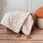 Découvrez la couverture pour bébé idéale pour apporter chaleur et douceur au quotidien de votre tout-petit ! Confectionnée à la main en France, cette couverture unique se compose d’une face au motif champignon enchanteur et d’une face en fausse fourrure sherpa beige extra douce, assurant confort et style. Pour un charme supplémentaire, quatre pompons couleur cassonade décorent élégamment chaque coin de la couverture. Et pour une touche encore plus personnelle, elle peut être brodée avec le prénom de votre b