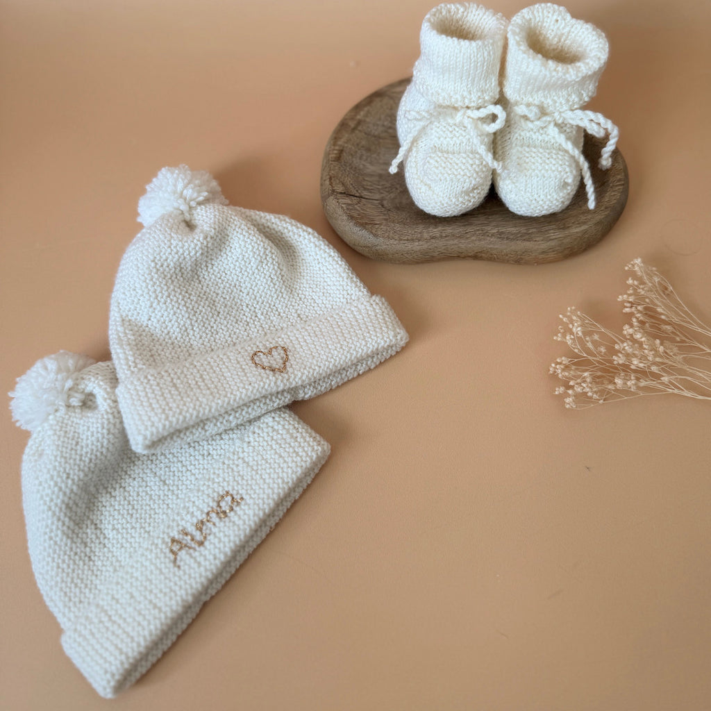 Le bonnet de naissance personnalisé pour bébé en maille tricotée de coton est l'accessoire idéal pour les premiers jours de votre nouveau-né. Confectionné avec soin, ce bonnet offre à votre bébé douceur et confort incomparables. Il est fabriqué dans l’un de nos ateliers partenaires français. Un cadeau parfaitement adapté pour accueillir votre petit trésor dans le monde avec tendresse et douceur. Retrouvez dans la même gamme, nos petits chaussons de naissance. Grâce à sa texture et à sa conception, ce bonnet