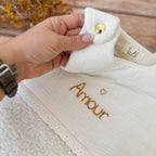 Cette gigoteuse pour bébé, confectionnée avec soin, est le choix idéal pour garder bébé au chaud durant l’hiver. Fabriquée en fausse fourrure type sherpa et en gaze de coton écrue, elle allie douceur et élégance. Son design raffiné, avec un empiècement en gaze de coton orné de délicate dentelle en broderie anglaise, en fait un accessoire de choix pour un sommeil cosy et stylé. Personnalisez la gigoteuse de bébé Vous avez la possibilité de personnaliser la gigoteuse avec le prénom ou le surnom de bébé, brodé