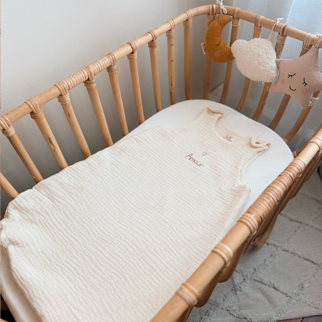 Gigoteuse d'Été en Triple Gaze de Coton Bio – Personnalisable Offrez à votre bébé un confort inégalé pendant les nuits d'été avec cette magnifique gigoteuse confectionnée dans une triple gaze de coton biologique certifiée Oeko-Tex, une matière d'exception bien plus douce et respirante que la traditionnelle double gaze. Sa texture gaufrée naturelle apporte douceur, légèreté et élégance. Disponible en coloris écru, cette gigoteuse est personnalisable au prénom de votre enfant, délicatement brodé sous un petit