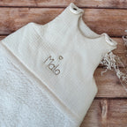 Cette gigoteuse pour bébé, confectionnée avec soin, est le choix idéal pour garder bébé au chaud durant l’hiver. Fabriquée en fausse fourrure type sherpa et en gaze de coton écrue, elle allie douceur et élégance. Son design raffiné, avec un empiècement en gaze de coton orné de délicate dentelle en broderie anglaise, en fait un accessoire de choix pour un sommeil cosy et stylé. Personnalisez la gigoteuse de bébé Vous avez la possibilité de personnaliser la gigoteuse avec le prénom ou le surnom de bébé, brodé