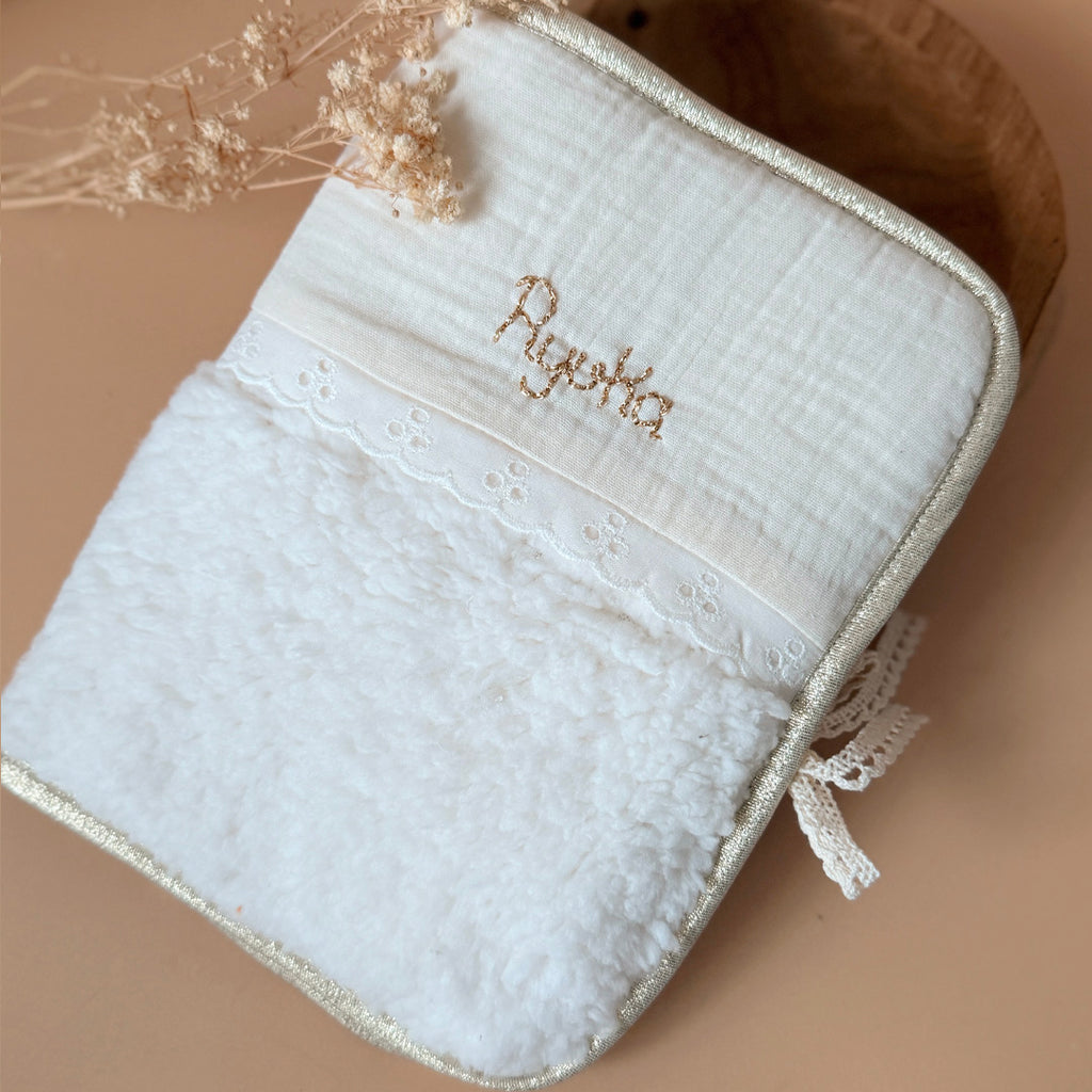 Pour protéger le carnet de santé tout en douceur et lui offrir une jolie enveloppe, voici l'accessoire qui rend les visites chez le médecin un peu plus gaies ! Fermeture au côté avec un joli lien en dentelle de coton.  Il est réalisé en fausse fourrure sherpa écrue avec notre jolie galon dentelle anglaise et gaze de coton. Son contour et biaisé par un ruban doré.