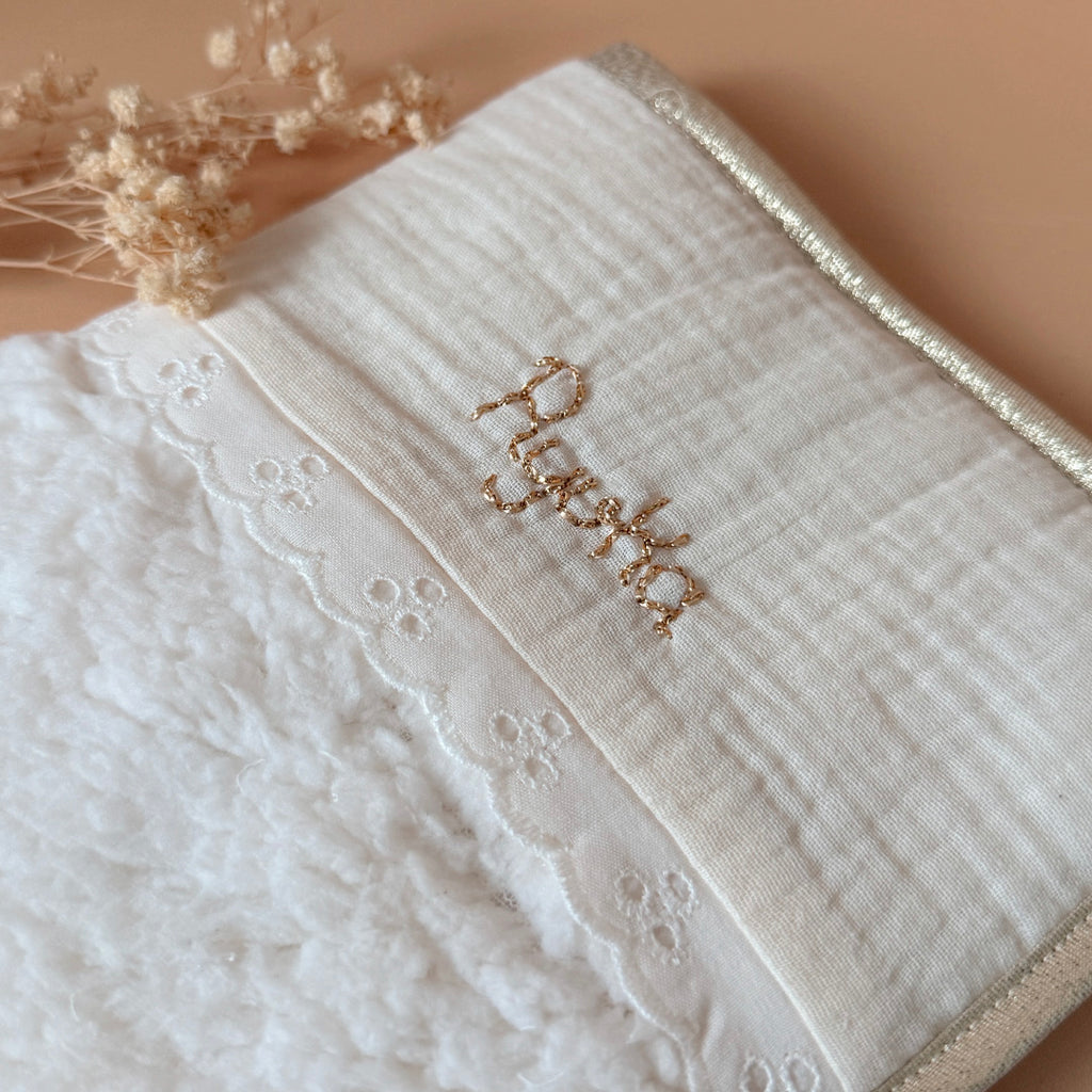 Pour protéger le carnet de santé tout en douceur et lui offrir une jolie enveloppe, voici l'accessoire qui rend les visites chez le médecin un peu plus gaies ! Fermeture au côté avec un joli lien en dentelle de coton.  Il est réalisé en fausse fourrure sherpa écrue avec notre jolie galon dentelle anglaise et gaze de coton. Son contour et biaisé par un ruban doré.