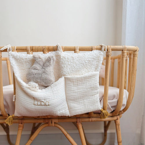 Idéal pour ranger les petites affaires de votre enfant, on met ses petites chaussettes, un livre, une tétine ... Le range doudou s'accroche sur un lit à barreau ou bien également sur un petit lit en bois esprit cabane,  à l'aide de ses trois liens en dentelle. Rangement très pratique, et peu encombrant, il sera parfait pour y glisser tout ce que vous voulez ! Son petit plus, un coté en fausse fourrure sherpa qui apporte une touche de douceur et cocooning à la décoration de chambre de votre enfant.