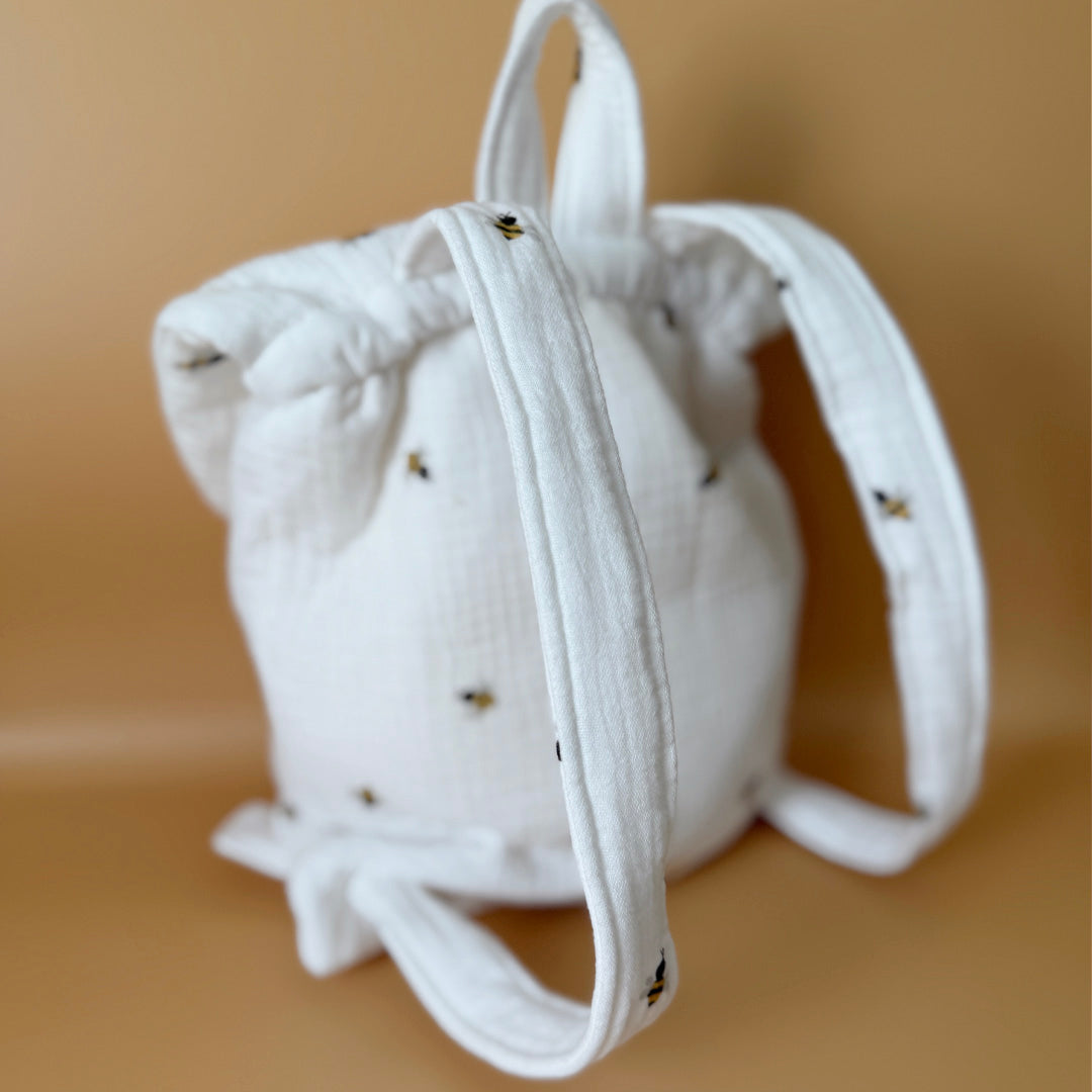 Adoptez notre tout nouveau sac à dos, il est idéal pour emporter le change, le biberon, la gourde, pour la crèche, la nounou mais aussi les premiers pas pour l'école ! Il est tout doux, tout mou et tout léger pour prendre soin du dos de votre enfant. Il est réalisé en 100% gaze de coton ouatiné , dans nos ateliers français. Notre emblématique pompon vient habillé le petit rabat qui est lui même muni d'une pression. Les anses sont ajustables en réglant les petits nœuds. Fabriqué en gaze de coton douce et res