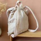 Adoptez notre tout nouveau sac à dos, il est idéal pour emporter le change, le biberon, la gourde, le départ pour la crèche, la nounou mais aussi les premiers pas pour l'école ! Il est tout doux, tout mou et tout léger pour prendre soin du dos de votre enfant. Il est réalisé en 100% gaze de coton ouatiné , dans nos ateliers français. Notre emblématique pompon vient habillé le petit rabat qui est lui même muni d'une pression. Les anses sont ajustables en réglant les petits nœuds.