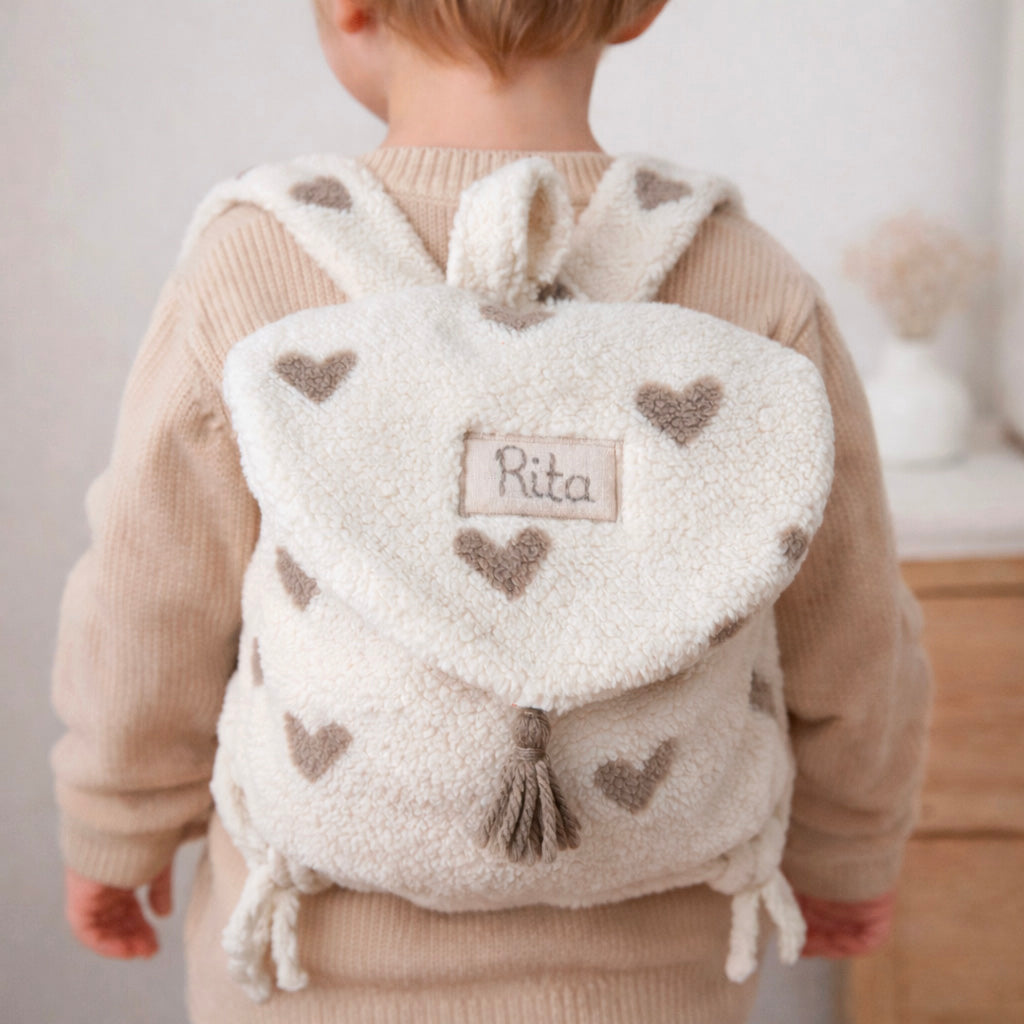 Adoptez notre tout nouveau sac à dos, il est idéal pour emporter le change, le biberon, la gourde, le départ pour la crèche, la nounou mais aussi les premiers pas pour l'école ! Il est tout doux, tout mou et tout léger pour prendre soin du dos de votre enfant. Il est réalisé en fausse fourrure sherpa,  ouatiné , dans nos ateliers français. Notre emblématique pompon vient habillé le petit rabat qui est lui même muni d'une pression. Les anses sont ajustables en réglant les petits nœuds. Fabriqué en sherpa  to