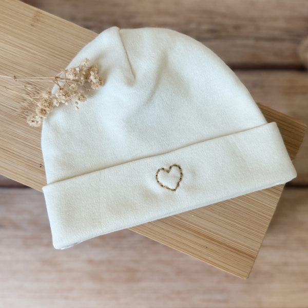 Immortaliser les premiers jours de vie de bébé avec ce joli petit bonnet personnalisé. Il est en 100% jersey de coton biologique écru. Il sera réchauffer bébé. Idéale pour annoncer le prénom de bébé à la naissance ! Le saviez-vous? Toutes les extrémités du corps de bébé sont les plus vulnérables au froid , pieds, mains, oreilles ... Même en plein été il est important de bien couvrir bébé dès la naissance, n'oublions pas qu'il sort d'un bain de 37° C depuis 9 mois !