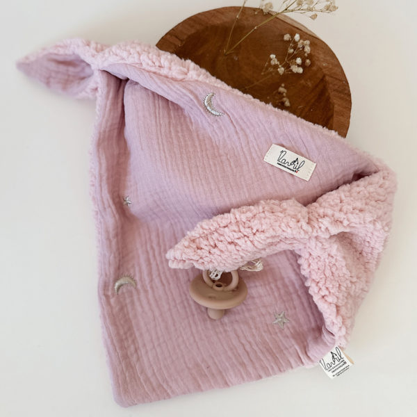 Quoi de mieux qu’un petit triangle tout doux, avec deux petites oreilles à malaxer ? Le doudou lange Charly, écharpe, lange d’allaitement… regorge de fonctions. Mais surtout bébé pourra le serrer contre lui et sentir son extrême douceur. Ce doudou lange deviendra le premier complice de bébé et sa source de réconfort pendant la sieste ou les moments câlins. Choisir le doudou lange Charly c'est promettre une véritable expérience tactile qui marquera vite la mémoire de bébé. Le doudou lange Charly comporte une face gaze de coton brodées avec de jolies lunes et étoiles. Elle est doublée de notre fameuse fausse fourrure ultra douce esprit mouton. Une association idéale pour un doudou ultra-câlin. 