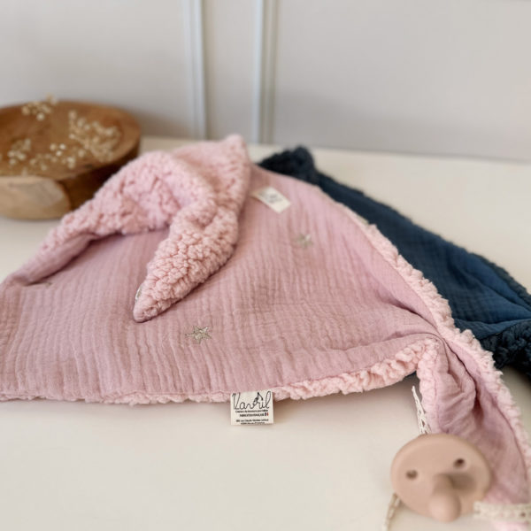 Quoi de mieux qu’un petit triangle tout doux, avec deux petites oreilles à malaxer ? Le doudou lange Charly, écharpe, lange d’allaitement… regorge de fonctions. Mais surtout bébé pourra le serrer contre lui et sentir son extrême douceur. Ce doudou lange deviendra le premier complice de bébé et sa source de réconfort pendant la sieste ou les moments câlins. Choisir le doudou lange Charly c'est promettre une véritable expérience tactile qui marquera vite la mémoire de bébé. Le doudou lange Charly comporte une face gaze de coton brodées avec de jolies lunes et étoiles. Elle est doublée de notre fameuse fausse fourrure ultra douce esprit mouton. Une association idéale pour un doudou ultra-câlin. 