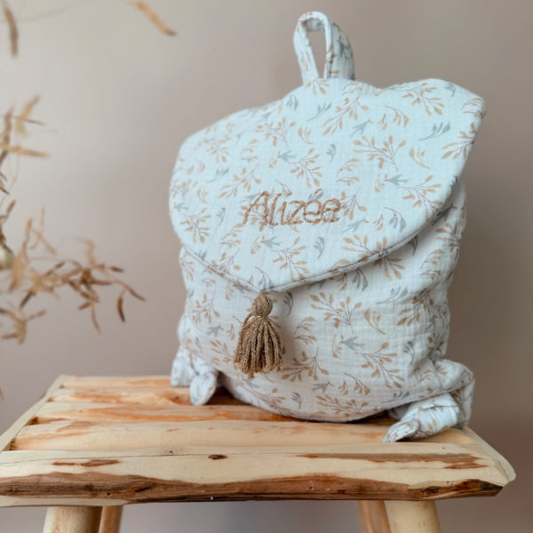 Adoptez notre tout nouveau sac à dos, il est idéal pour emporter le change, le biberon, la gourde, le départ pour la crèche, la nounou mais aussi les premiers pas pour l'école ! Il est tout doux, tout mou et tout léger pour prendre soin du dos de votre enfant. Il est réalisé en 100% gaze de coton ouatiné , dans nos ateliers français. Notre emblématique pompon vient habillé le petit rabat qui est lui même muni d'une pression. Les anses sont ajustables en réglant les petits nœuds. Fabriqué en gaze de coton douce et respirante, ce sac à dos assure le confort de votre bébé tout en étant délicat pour sa peau sensible. Doté de bretelles réglables et d'une poignée de transport pratique, ce sac à dos est parfaitement adapté à la morphologie de votre enfant et offre une grande facilité d'utilisation. Idéal pour les sorties en famille, les promenades au parc ou les voyages, ce sac à dos offre suffisamment d'espace pour ranger les essentiels de bébé tout en restant léger et compact.