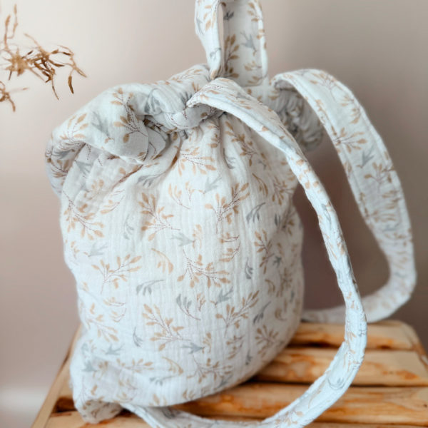 Adoptez notre tout nouveau sac à dos, il est idéal pour emporter le change, le biberon, la gourde, le départ pour la crèche, la nounou mais aussi les premiers pas pour l'école ! Il est tout doux, tout mou et tout léger pour prendre soin du dos de votre enfant. Il est réalisé en 100% gaze de coton ouatiné , dans nos ateliers français. Notre emblématique pompon vient habillé le petit rabat qui est lui même muni d'une pression. Les anses sont ajustables en réglant les petits nœuds. Fabriqué en gaze de coton douce et respirante, ce sac à dos assure le confort de votre bébé tout en étant délicat pour sa peau sensible. Doté de bretelles réglables et d'une poignée de transport pratique, ce sac à dos est parfaitement adapté à la morphologie de votre enfant et offre une grande facilité d'utilisation. Idéal pour les sorties en famille, les promenades au parc ou les voyages, ce sac à dos offre suffisamment d'espace pour ranger les essentiels de bébé tout en restant léger et compact.