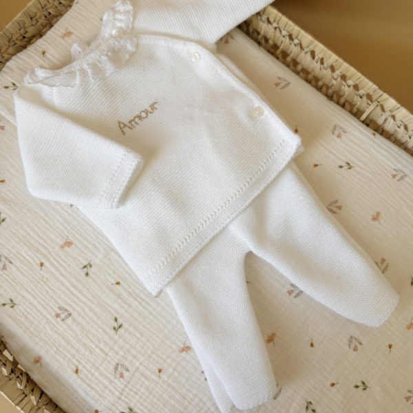 Offrez à votre nouveau-né douceur et confort avec notre petit pantalon de naissance en maille, couleur blanc. Conçu spécialement pour les tout-petits, ce pantalon est tricoté avec soin en France, dans une maille souple et agréable, parfaite pour la peau délicate des bébés. Sa taille élastiquée assure un ajustement confortable sans comprimer le ventre de bébé, tout en facilitant l’habillage au quotidien. Minimaliste et élégant, il est idéal dès les premiers jours de vie, que ce soit pour rester bien au chaud à la maison ou pour les premières sorties. Associez ce pantalon avec notre brassière en maille blanche à petit col brodé pour composer une tenue harmonieuse et pleine de tendresse. Un ensemble parfait pour une naissance ou un cadeau de maternité. Sa maille tricot est réalisée en fils de coton, Son toucher est doux et léger, ce qui en fait une brassière parfait pour les bébés dont la naissance est prévue au printemps ou en été.  De plus, son séchage est très rapide après un lavage doux en machine.