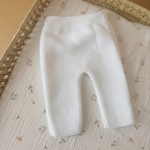 Offrez à votre nouveau-né douceur et confort avec notre petit pantalon de naissance en maille, couleur blanc. Conçu spécialement pour les tout-petits, ce pantalon est tricoté avec soin en France, dans une maille souple et agréable, parfaite pour la peau délicate des bébés. Sa taille élastiquée assure un ajustement confortable sans comprimer le ventre de bébé, tout en facilitant l’habillage au quotidien. Minimaliste et élégant, il est idéal dès les premiers jours de vie, que ce soit pour rester bien au chaud à la maison ou pour les premières sorties. Associez ce pantalon avec notre brassière en maille blanche à petit col brodé pour composer une tenue harmonieuse et pleine de tendresse. Un ensemble parfait pour une naissance ou un cadeau de maternité. Sa maille tricot est réalisée en fils de coton, Son toucher est doux et léger, ce qui en fait une brassière parfait pour les bébés dont la naissance est prévue au printemps ou en été.  De plus, son séchage est très rapide après un lavage doux en machine.