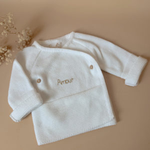 Pour un nourrisson, de la naissance à un mois environ, il est recommandé de rajouter une brassière de naissance en coton  et un bonnet.  À cet âge bébé est encore trop petit pour réguler lui-même sa température. Bébé a besoin de chaleur et de matières douces et rassurantes, c'est pourquoi ce cardigan croisé est un parfait cocon pour accueillir bébé ! Elle a une place indispensable dans le trousseau de maternité. Complétez votre tenue avec un de nos petits bonnets personnalisés et nos petits chaussons de naissance. Notre brassière bébé est confortable et très élégante. Avec sa petite maille 100% coton, cette brassière offre un style unique et très chic ! Tricotée en France dans la région roannaise, notre brassière est respectueuse du savoir faire français.  Cette brassière en plus d’être douce et confortable a été pensé afin d’habiller bébé le plus facilement possible : pour une fermeture facile, de petits boutons sont situés sur le côté ce qui vous permettra de changer bébé très aisément. Sa maille tricot est réalisée en fils de coton, Son toucher est doux et léger, ce qui en fait une brassière parfait pour les bébés dont la naissance est prévue au printemps ou en été.  De plus, son séchage est très rapide après un lavage doux en machine.