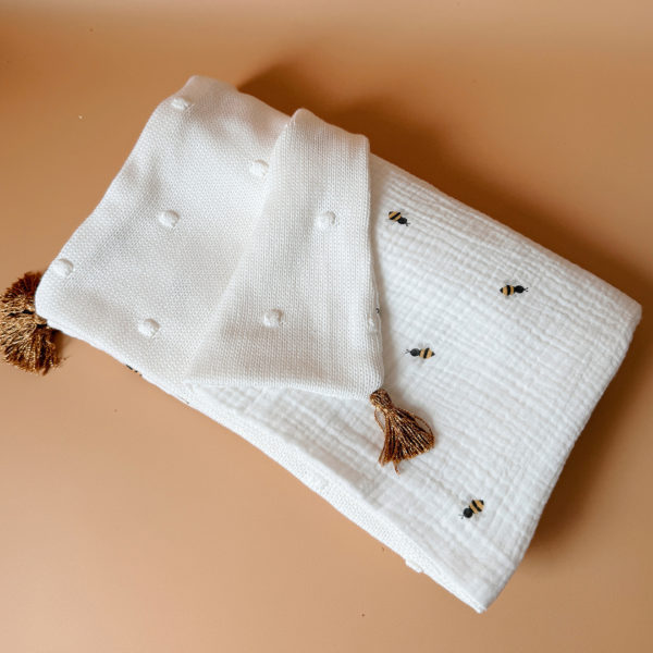 Parce qu’il est important de couvrir bébé même l’été, nous avons développé cette couverture 100% coton. Dès son arrivée, bébé passe d'un environnement clos de 37°C à une température extérieure que l’on ne peut pas toujours contrôler. En sortie avec un petit bébé d’été, vous pourriez vite être incommodés par un climatiseur. Bébé sera sensible aux petits coups de vent ou aux changements de températures en soirée. Bébé aura besoin également d’être tenu au chaud pendant la sieste (la température du corps descend lorsque nous dormons et sommes immobiles). C’est pour cela que nous avons conçu cette grande couverture d’été respirante, douce et hypoallergénique. Retrouvez notre gamme complète de couvertures d'été personnalisées. Ni trop légère ni trop chaude, elle est idéale pour réchauffer bébé de manière naturelle grâce à sa composition en gaze de coton (100%) Oeko-Tex et en maille de coton avec ces jolis petits pois en relief,  ce qui assure une vraie respiration cutanée. Comme toutes nos couvertures elle est très souple et enveloppera parfaitement bébé.