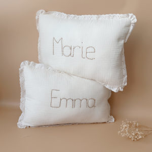 Offrez à la chambre de votre enfant une touche d'élégance et de douceur avec ce coussin rectangulaire très raffiné. Confectionné avec soin, il allie la gaze de coton et la maille de nid d'abeille grattée, des matériaux à la fois légers, aérés et agréables au toucher. Son coloris écru intemporel s'intégrera parfaitement dans tout type de décoration, apportant à la pièce une ambiance chaleureuse et apaisante. Ce coussin n'est pas seulement un accessoire de décoration, il devient aussi un objet personnalisé et unique. Broder le prénom de votre enfant ou un mot doux de votre choix sur le coussin pour en faire un cadeau original et sur mesure. Retrouvez toute notre ligne maille dentelée chic et intemporelle ici.