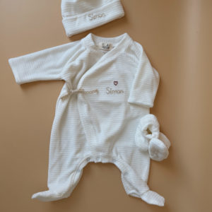 Offrez à votre nouveau-né un confort absolu avec notre pyjama de naissance écru en maille côtelée, soigneusement fabriqué en France. Ce pyjama allie douceur et praticité, idéal pour les premiers mois de bébé. Son design élégant en maille de velours côtelé offre une texture agréable au toucher, tandis que sa teinte écrue apporte une touche intemporelle. Il se distingue par sa personnalisation au prénom de votre enfant, en faisant un cadeau unique et inoubliable. Pratique, il est doté d'une fermeture sur le devant pour faciliter l'habillage, ainsi qu'une ouverture intégrale au niveau des pieds, rendant le changement de couches simple et rapide. Un incontournable pour le trousseau de naissance, conçu pour offrir à votre bébé le meilleur dès ses premiers jours. Un cadeau parfaitement adapté pour accueillir votre petit trésor dans le monde avec tendresse et douceur. Retrouvez dans la même gamme, nos petits chaussons de naissance ainsi que nos bonnets.