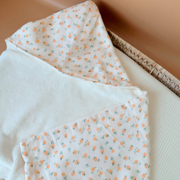 Faites de chaque moment de bain un moment de douceur et de confort pour votre tout-petit avec notre cape de bain XXL. Grâce à son maxi format, elle convient pour les enfants de 0 à 5 ans. Fabriquée en France avec une micro-éponge de bambou écrue de qualité supérieure, cette cape offre une absorption optimale et une sensation de luxe à chaque utilisation. Cette cape de bain généreuse est conçue pour envelopper confortablement votre bébé, offrant une couverture totale. Ainsi votre enfant est bien enveloppé à la sortie du bain tout en favorisant sa chaleur corporelle après le bain. La capuche intégrée permet de garder la tête de votre bébé au chaud et offre un séchage rapide des cheveux. Agrémentée d'un doux imprimé aux motifs estivaux, cette cape de bain apporte une touche de fraîcheur et de gaieté à l'heure du bain. Grâce à la matière en micro-éponge de bambou, cette matière naturelle est douce pour la peau délicate de votre bébé.  Elle est également très absorbante et respectueuse de l'environnement. Convient aux bébés et aux petits jusqu'à l'âge de 5 ans. Cette cape de bain est un indispensable de la trousse de toilette de votre enfant, que ce soit à la maison, à la plage ou à la piscine.