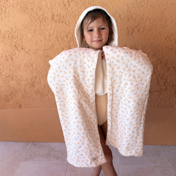 Faites de chaque moment de bain un moment de douceur et de confort pour votre tout-petit avec notre cape de bain XXL. Grâce à son maxi format, elle convient pour les enfants de 0 à 5 ans. Fabriquée en France avec une micro-éponge de bambou écrue de qualité supérieure, cette cape offre une absorption optimale et une sensation de luxe à chaque utilisation. Cette cape de bain généreuse est conçue pour envelopper confortablement votre bébé, offrant une couverture totale. Ainsi votre enfant est bien enveloppé à la sortie du bain tout en favorisant sa chaleur corporelle après le bain. La capuche intégrée permet de garder la tête de votre bébé au chaud et offre un séchage rapide des cheveux. Agrémentée d'un doux imprimé aux motifs estivaux, cette cape de bain apporte une touche de fraîcheur et de gaieté à l'heure du bain. Grâce à la matière en micro-éponge de bambou, cette matière naturelle est douce pour la peau délicate de votre bébé.  Elle est également très absorbante et respectueuse de l'environnement.