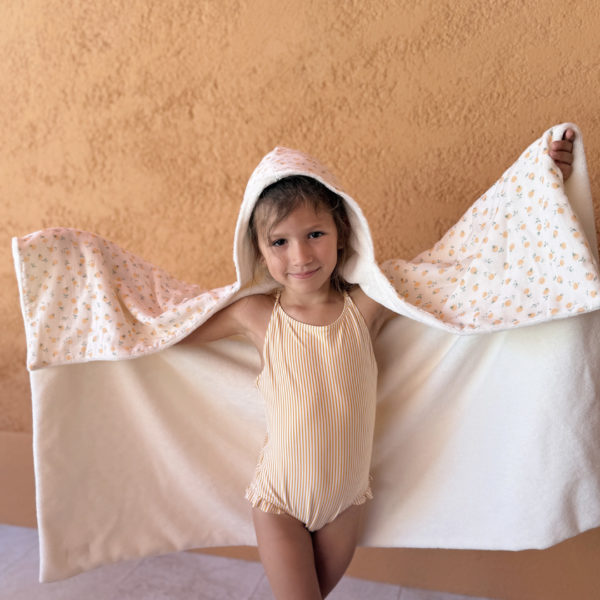Faites de chaque moment de bain un moment de douceur et de confort pour votre tout-petit avec notre cape de bain XXL. Grâce à son maxi format, elle convient pour les enfants de 0 à 5 ans. Fabriquée en France avec une micro-éponge de bambou écrue de qualité supérieure, cette cape offre une absorption optimale et une sensation de luxe à chaque utilisation. Cette cape de bain généreuse est conçue pour envelopper confortablement votre bébé, offrant une couverture totale. Ainsi votre enfant est bien enveloppé à la sortie du bain tout en favorisant sa chaleur corporelle après le bain. La capuche intégrée permet de garder la tête de votre bébé au chaud et offre un séchage rapide des cheveux. Agrémentée d'un doux imprimé aux motifs estivaux, cette cape de bain apporte une touche de fraîcheur et de gaieté à l'heure du bain. Grâce à la matière en micro-éponge de bambou, cette matière naturelle est douce pour la peau délicate de votre bébé.  Elle est également très absorbante et respectueuse de l'environnement.