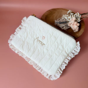 Apportez une touche de tendresse à vos accessoires avec cette trousse  matelassée en jersey de coton, entièrement confectionnée en France. Pensée pour les mamans, les enfants ou tout simplement pour se faire plaisir, cette trousse incarne à la fois le charme artisanal et la fonctionnalité. Son tissu matelassé lui confère une allure douce et moelleuse, parfaite pour y glisser les essentiels de toilette ou les petits trésors du quotidien. Ce qui la rend unique ? Sa jolie broderie Maman , effectuée sur le devant de la trousse.  Idéale comme cadeau de naissance, de babyshower, ou pour toute occasion où l’on veut faire plaisir avec du fait-main de qualité. Fièrement fabriquée en France, cette trousse de toilette est le fruit d'un savoir-faire artisanal et d'une attention particulière aux détails. Zoom sur le petit curseur de la fermeture à glissière !