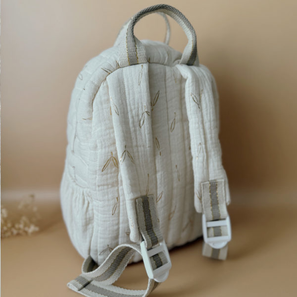 Voici notre tout nouveau sac à dos maternelle, pensé et confectionné en France pour accompagner vos tout-petits dans leurs premières journées d'école. Ce modèle délicat est réalisé en gaze de coton matelassée écrue, ornée de petites feuilles dorées qui lui donnent une allure douce et poétique. La grande particularité de ce sac ? Il est personnalisé avec le prénom de votre enfant, brodé à la main en fil doré sur la poche avant. Un détail unique, raffiné, et tellement précieux pour marquer les affaires de votre petit. L’intérieur du sac est entièrement doublé avec un tissu imperméable, parfait pour protéger son contenu contre les petits accidents ou les surprises météo. Son ouverture zippée large a été pensée pour que les enfants puissent l’utiliser en toute autonomie. Il comporte trois poches intelligentes, dont deux latérales élastiquées idéales pour glisser une gourde, un doudou ou les trésors ramassés à la récréation. Côté confort, rien n’a été laissé au hasard : bretelles matelassées réglables et ajustables pour un bon maintien sans tirer sur les épaules, et deux anses solides pour une prise en main facile par les petits ou les adultes. C'est plus qu’un sac à dos : c’est un vrai compagnon de rentrée, beau, pratique, doux pour le dos, et surtout unique grâce à sa personnalisation.