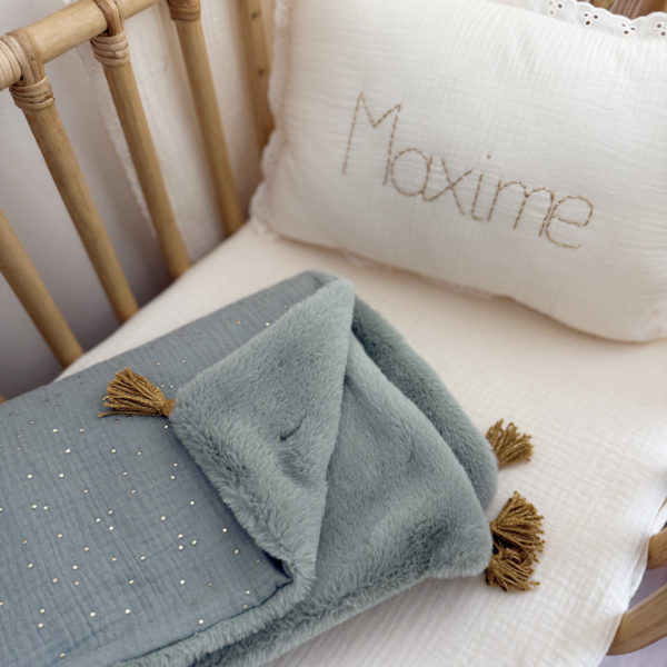 La couverture est une des pièces indispensable du trousseau de bébé. Parfaite en cadeau de naissance ou à s’offrir soit même, cette couverture chaude spéciale “bébés d’hiver”, vous accompagnera très longtemps dans vos moments câlins avec bébé. Les bébés d’hiver qui naissent pendant les mois les plus froids ont besoin d'être tenus bien au chaud à la sortie du ventre de maman. C'est pourquoi nous avons conçu cette couverture chaude spéciale “bébé d’hiver”. Dès son arrivée, bébé passe d'un environnement clos de 37°C à une température extérieure souvent très basse en hiver. C'est pour cela que nos couvertures d'hiver sont idéales pour réguler et maintenir une bonne température pour le corps de bébé.  Cette grande couverture pourra également être utilisée en descente de lit quand bébé sera plus grand. Cette couverture est idéale pour bien réchauffer les bébés d’hiver grâce à sa fausse fourrure extra douce, très épaisse (365g/m2), et sa doublure en gaze de coton hypoallergénique au magnifique motif d'un doux feuillage et de petites hirondelles. Un motif doux et unisexe. Quatre pompons en laine doré viennent sublimer la couverture dans les angles. Ils sont fabriqués à la main pour une pièce encore plus unique. Chaque pompon est posé très fermement avec des points solides afin de garantir une sécurité optimale pour votre enfant.