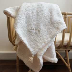Apportez chaleur, tendresse et raffinement à votre quotidien avec cette magnifique couverture personnalisable, confectionnée avec soin en France. Un véritable cocon de douceur, pensé pour envelopper les petits et les grands dans un nuage de confort. Un textile d’exception, doux et élégant Cette grande couverture de 105 x 130 cm marie subtilement deux matières nobles et douces : Une face en gaze de coton brodée, inspirée de la broderie anglaise, légère et respirante, aux motifs floraux délicats qui évoquent la tendresse de l’enfance. Une face en fausse fourrure sherpa, épaisse et ultra-douce, idéale pour réchauffer les journées fraîches ou les soirées d’hiver. Le tout assemblé avec amour dans un atelier français, pour un résultat à la fois esthétique, pratique et durable. Une couverture unique grâce à la personnalisation Pour rendre cette couverture vraiment unique, nous vous proposons une broderie à la main du prénom, d’un mot doux ou d’une petite phrase de votre choix (ex. : Amour, Petit trésor, Louise, Mon bébé d’hiver…). Chaque broderie est réalisée avec soin, dans une teinte douce et naturelle, parfaitement en harmonie avec la couverture. 👉 Cette option de personnalisation en fait un cadeau de naissance idéal, un souvenir précieux à conserver pour la vie.