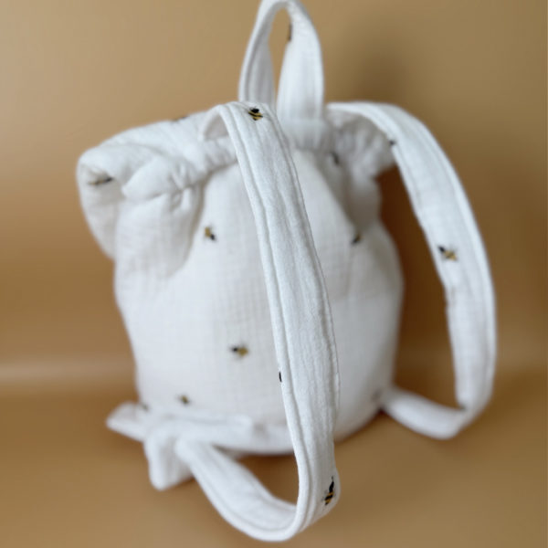 Adoptez notre tout nouveau sac à dos, il est idéal pour emporter le change, le biberon, la gourde, pour la crèche, la nounou mais aussi les premiers pas pour l'école ! Il est tout doux, tout mou et tout léger pour prendre soin du dos de votre enfant. Il est réalisé en 100% gaze de coton ouatiné , dans nos ateliers français. Notre emblématique pompon vient habillé le petit rabat qui est lui même muni d'une pression. Les anses sont ajustables en réglant les petits nœuds. Fabriqué en gaze de coton douce et respirante, ce sac à dos assure le confort de votre bébé tout en étant délicat pour sa peau sensible. Doté de bretelles réglables et d'une poignée de transport pratique, ce sac à dos est parfaitement adapté à la morphologie de votre enfant et offre une grande facilité d'utilisation. Idéal pour les sorties en famille, les promenades au parc ou les voyages, ce sac à dos offre suffisamment d'espace pour ranger les essentiels de bébé tout en restant léger et compact.