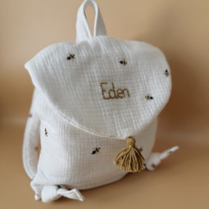 Adoptez notre tout nouveau sac à dos, il est idéal pour emporter le change, le biberon, la gourde, pour la crèche, la nounou mais aussi les premiers pas pour l'école ! Il est tout doux, tout mou et tout léger pour prendre soin du dos de votre enfant. Il est réalisé en 100% gaze de coton ouatiné , dans nos ateliers français. Notre emblématique pompon vient habillé le petit rabat qui est lui même muni d'une pression. Les anses sont ajustables en réglant les petits nœuds. Fabriqué en gaze de coton douce et respirante, ce sac à dos assure le confort de votre bébé tout en étant délicat pour sa peau sensible. Doté de bretelles réglables et d'une poignée de transport pratique, ce sac à dos est parfaitement adapté à la morphologie de votre enfant et offre une grande facilité d'utilisation. Idéal pour les sorties en famille, les promenades au parc ou les voyages, ce sac à dos offre suffisamment d'espace pour ranger les essentiels de bébé tout en restant léger et compact.