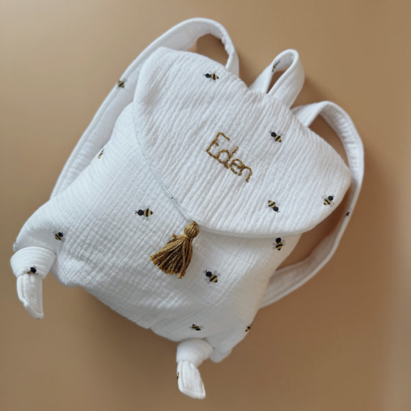 Adoptez notre tout nouveau sac à dos, il est idéal pour emporter le change, le biberon, la gourde, pour la crèche, la nounou mais aussi les premiers pas pour l'école ! Il est tout doux, tout mou et tout léger pour prendre soin du dos de votre enfant. Il est réalisé en 100% gaze de coton ouatiné , dans nos ateliers français. Notre emblématique pompon vient habillé le petit rabat qui est lui même muni d'une pression. Les anses sont ajustables en réglant les petits nœuds. Fabriqué en gaze de coton douce et respirante, ce sac à dos assure le confort de votre bébé tout en étant délicat pour sa peau sensible. Doté de bretelles réglables et d'une poignée de transport pratique, ce sac à dos est parfaitement adapté à la morphologie de votre enfant et offre une grande facilité d'utilisation. Idéal pour les sorties en famille, les promenades au parc ou les voyages, ce sac à dos offre suffisamment d'espace pour ranger les essentiels de bébé tout en restant léger et compact.
