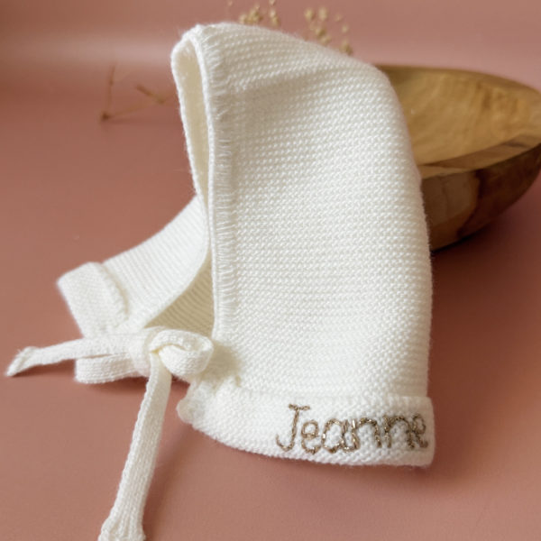 Le petit béguin de naissance, un incontournable dans la valise maternité Délicatement tricotée dans une douce laine alpaga écru, ce petit béguin respire l'élégance et la délicatesse, parfait pour les premiers jours de votre nouveau-né. Ce béguin peut être personnalisé avec le prénom de votre bébé, ajoutant une touche personnelle. Offrez à votre enfant un accessoire à la fois pratique et chargé d'émotion, idéal pour immortaliser ces précieux moments. Un cadeau parfaitement adapté pour accueillir votre petit trésor dans le monde avec tendresse et douceur. Son design simple et élégant s'accorde facilement avec toutes les tenues de bébé. Notamment avec notre douce brassière de naissance ajourée écrue.